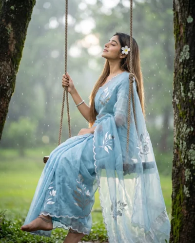 AI-generated image: Cinematic Blue Saree AI Prompt: Woman on Swing in Rain